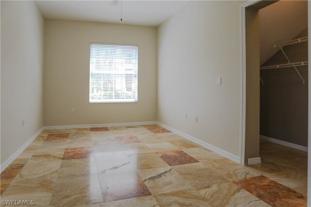 unfurnished bedroom with a spacious closet, a closet, and light tile patterned floors