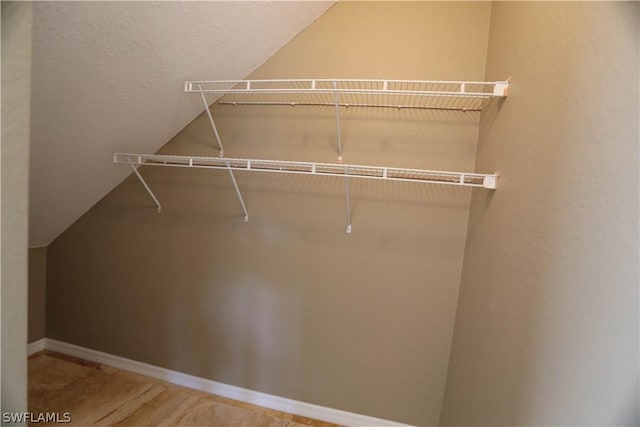 walk in closet with vaulted ceiling