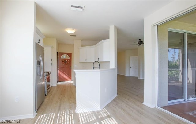 kitchen with stainless steel appliances, sink, light hardwood / wood-style floors, and white cabinets