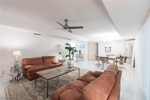 tiled living room with a textured ceiling and ceiling fan with notable chandelier