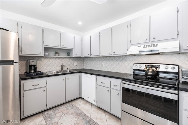 kitchen featuring tasteful backsplash, light tile patterned floors, and stainless steel appliances