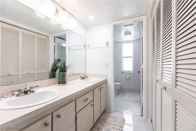 bathroom with tile patterned flooring, double sink vanity, and toilet