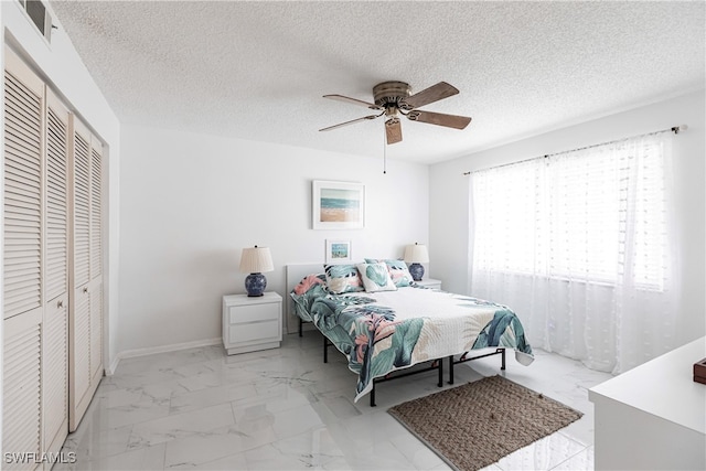 tiled bedroom featuring a closet, a textured ceiling, and ceiling fan