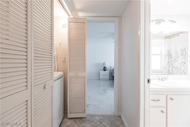 bathroom with washer / dryer, vanity, and tile patterned floors