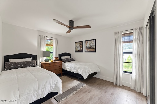 bedroom featuring multiple windows, light wood-type flooring, and ceiling fan