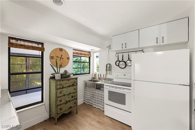 kitchen with white cabinetry, sink, white appliances, and light wood-type flooring