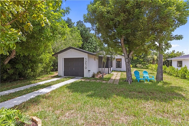 ranch-style home featuring a garage and a front lawn