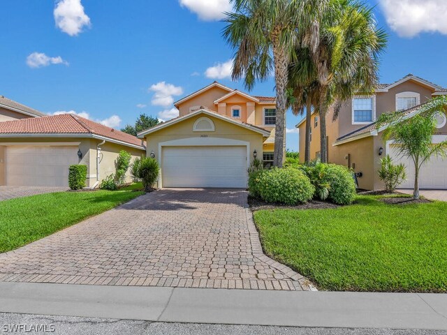 mediterranean / spanish home with a front yard and a garage