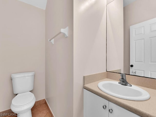 bathroom with toilet, vanity, and tile patterned floors