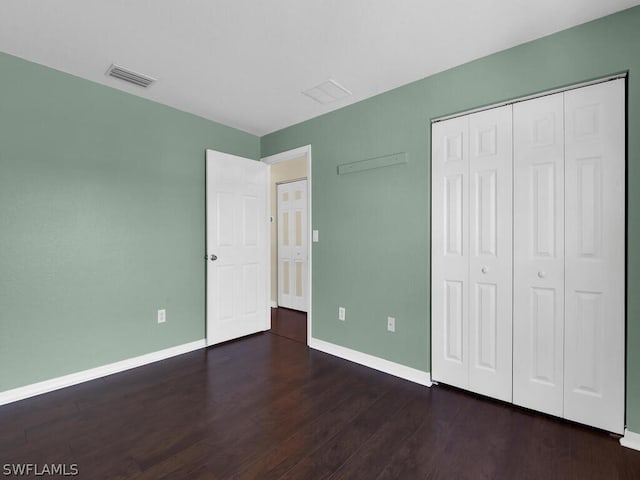 unfurnished bedroom featuring dark hardwood / wood-style flooring and a closet