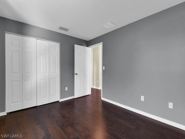 unfurnished bedroom featuring dark hardwood / wood-style flooring and a closet