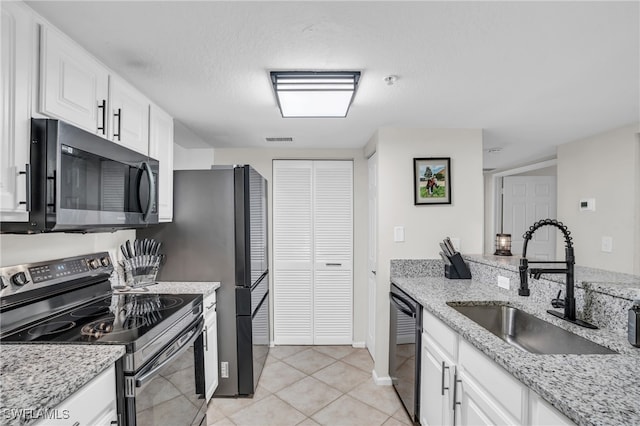 kitchen featuring white cabinets, light tile patterned floors, electric range oven, and sink