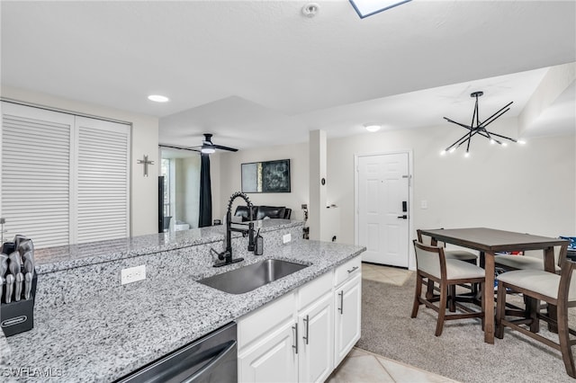 kitchen featuring light tile patterned flooring, ceiling fan, white cabinets, sink, and light stone counters