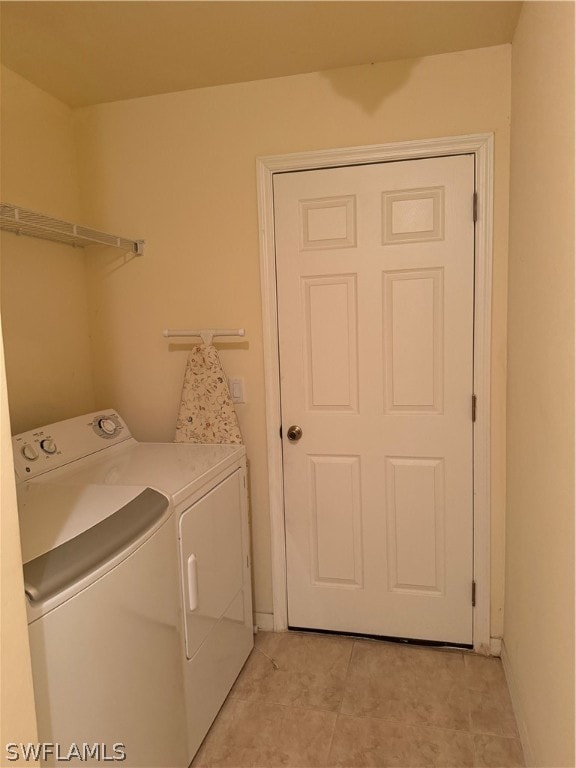 clothes washing area featuring light tile patterned flooring and separate washer and dryer