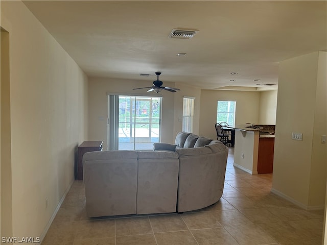 tiled living room with a healthy amount of sunlight and ceiling fan