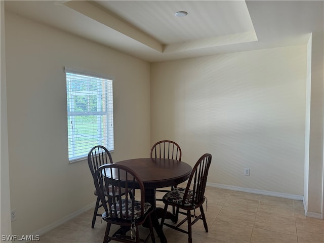 dining room featuring a raised ceiling and light tile patterned floors