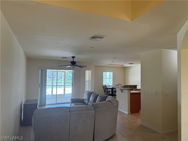 tiled living room with ceiling fan