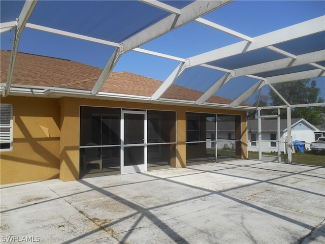 back of property featuring a patio and glass enclosure