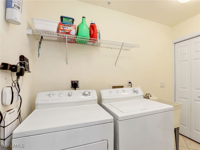 laundry room featuring washer and clothes dryer and light tile patterned floors