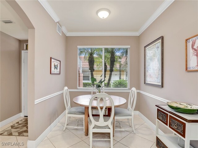 tiled dining area featuring crown molding