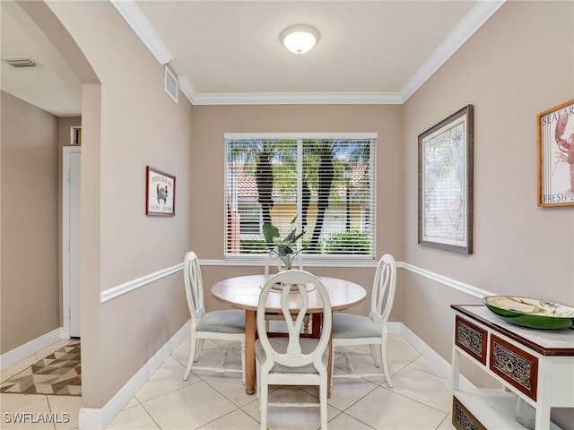 dining area with light tile patterned floors and crown molding