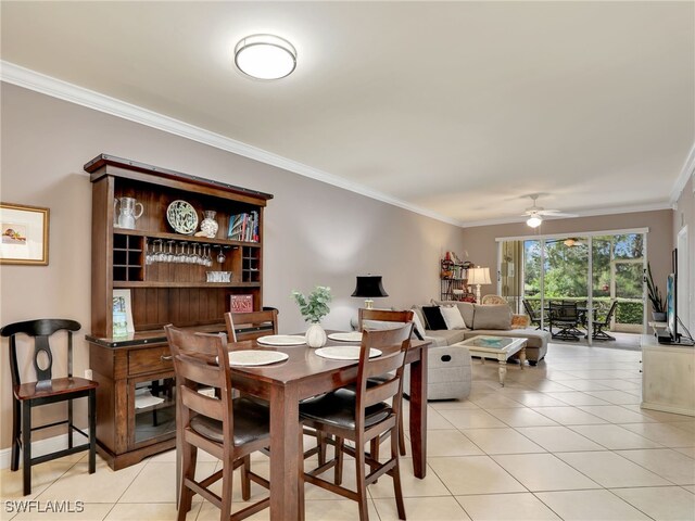 tiled dining room with ornamental molding and ceiling fan