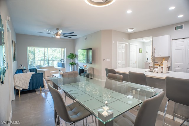 dining room with ceiling fan and tile patterned floors