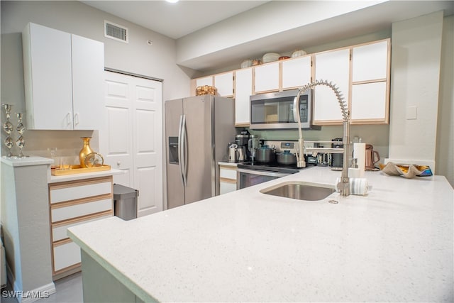 kitchen featuring white cabinets, kitchen peninsula, and stainless steel appliances