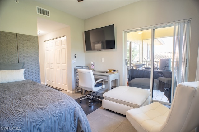 tiled bedroom with access to outside and a closet