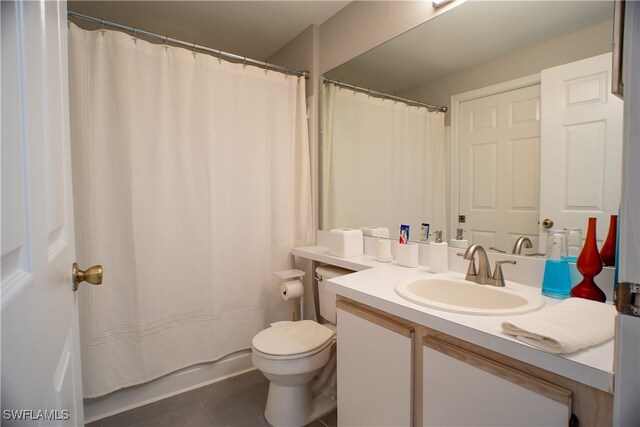 bathroom featuring toilet, a shower with shower curtain, vanity, and tile patterned floors