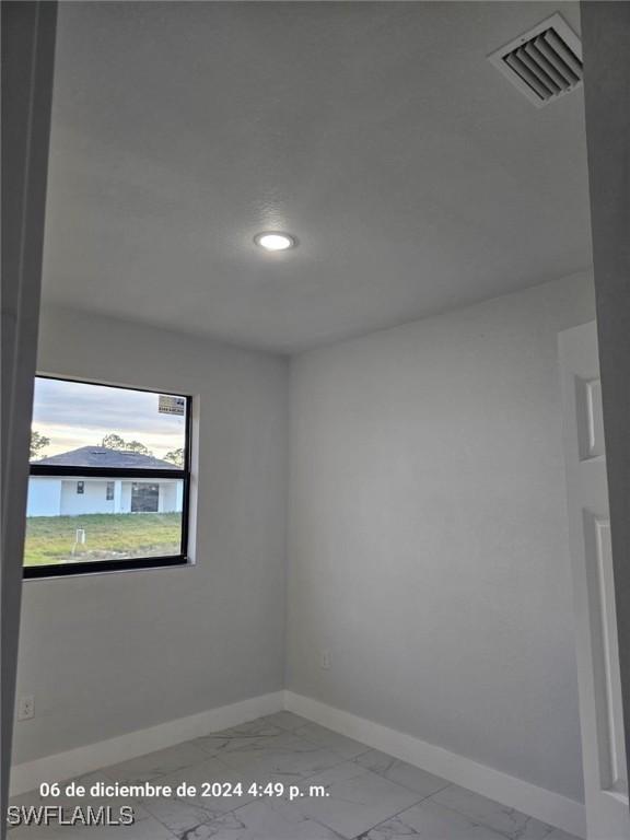 2801 48th St W, Lehigh Acres, FL 33971 - spare room featuring recessed lighting, visible vents, marble finish floor, and baseboards