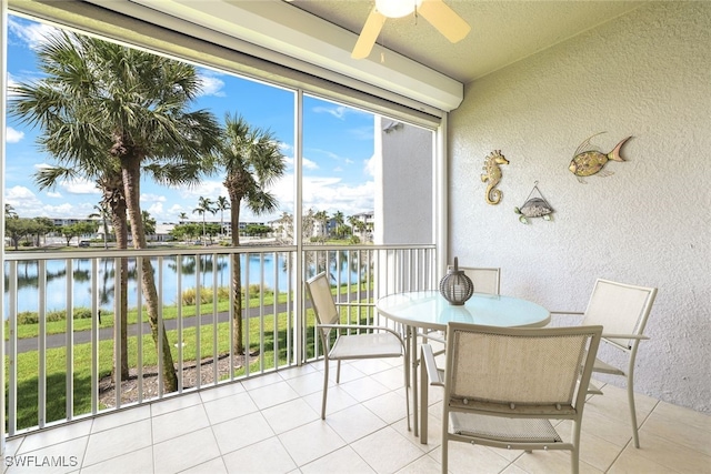 sunroom with a water view and ceiling fan