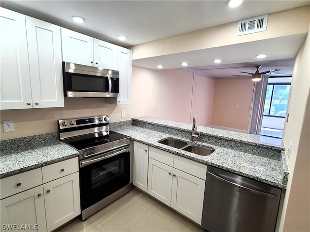 kitchen featuring light stone countertops, appliances with stainless steel finishes, and sink