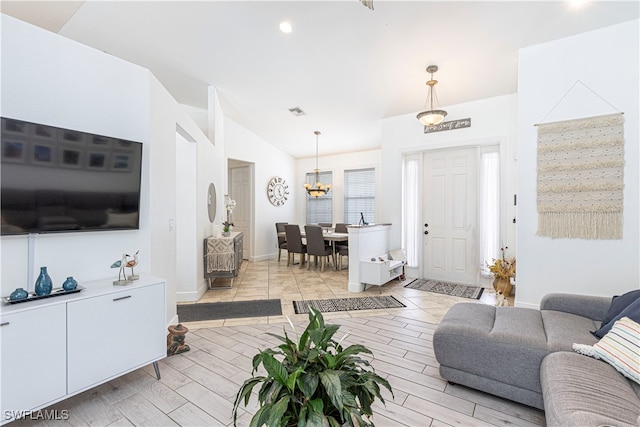 living room featuring a notable chandelier and vaulted ceiling