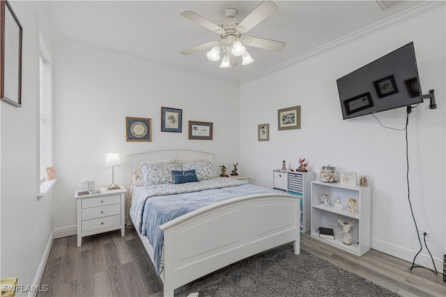 bedroom featuring ceiling fan, crown molding, and wood-type flooring