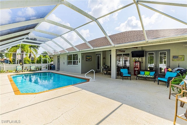 view of pool with french doors, a patio area, and glass enclosure