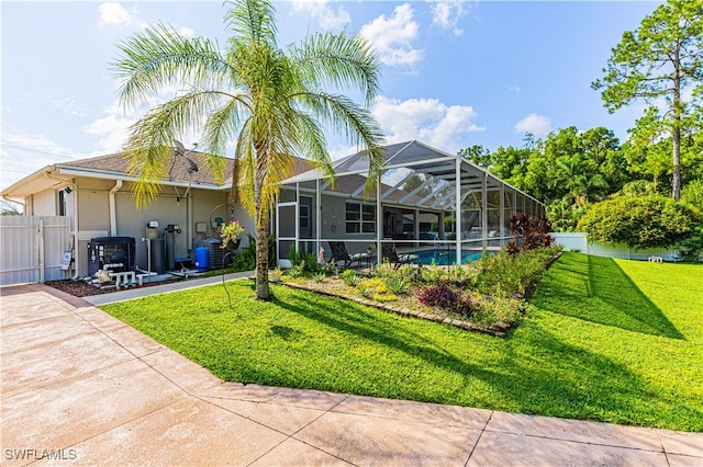 back of property featuring a lanai, a patio area, a yard, and a fenced in pool