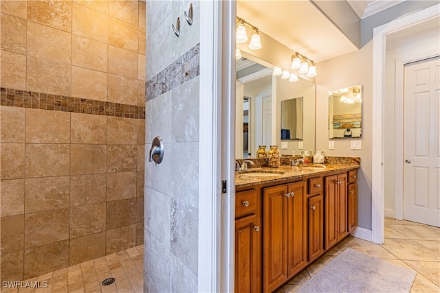 bathroom with crown molding, tiled shower, and vanity