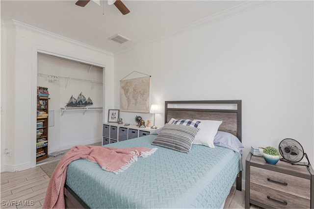 bedroom featuring ornamental molding, light wood-type flooring, ceiling fan, and a closet