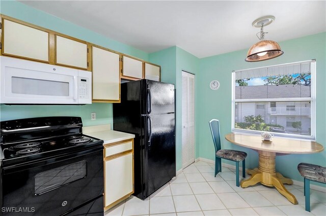 kitchen with decorative light fixtures, black appliances, white cabinetry, and light tile patterned floors