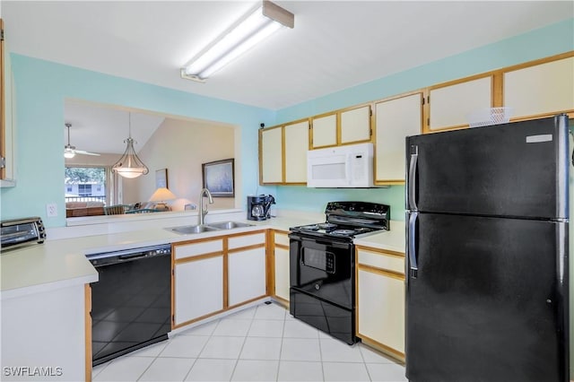 kitchen featuring light countertops, hanging light fixtures, a sink, and black appliances