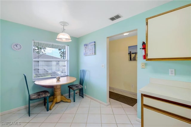 dining space featuring light tile patterned floors, baseboards, and visible vents