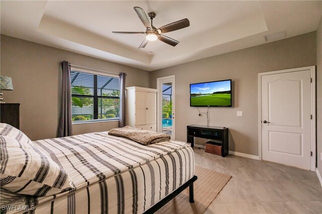 tiled bedroom with access to exterior, ceiling fan, and a raised ceiling