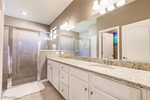 bathroom with tile patterned floors, walk in shower, and dual bowl vanity