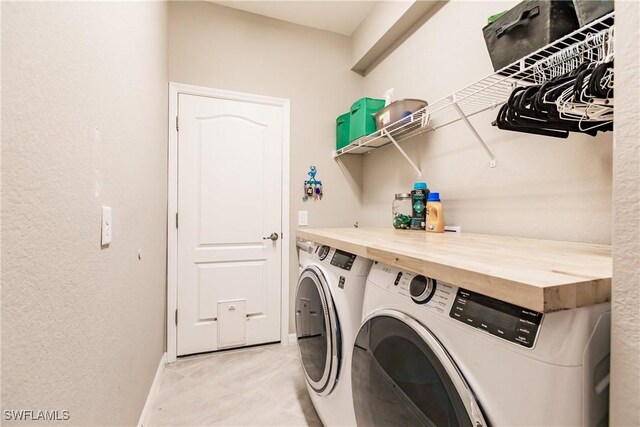 clothes washing area with light tile patterned flooring and independent washer and dryer