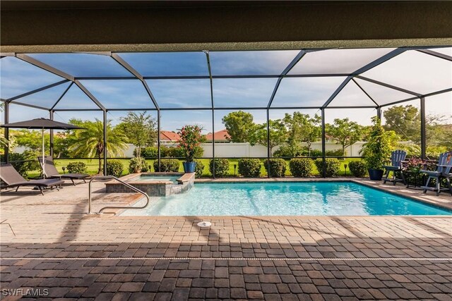 view of pool with a patio, an in ground hot tub, and glass enclosure