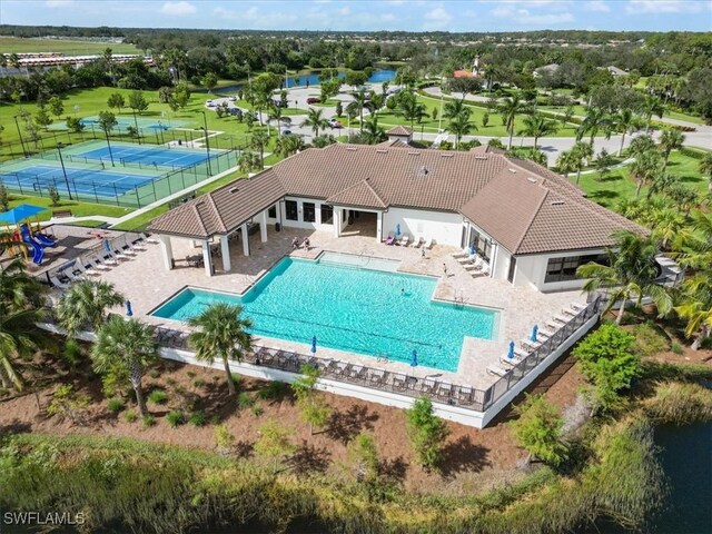 view of pool with tennis court and a patio area