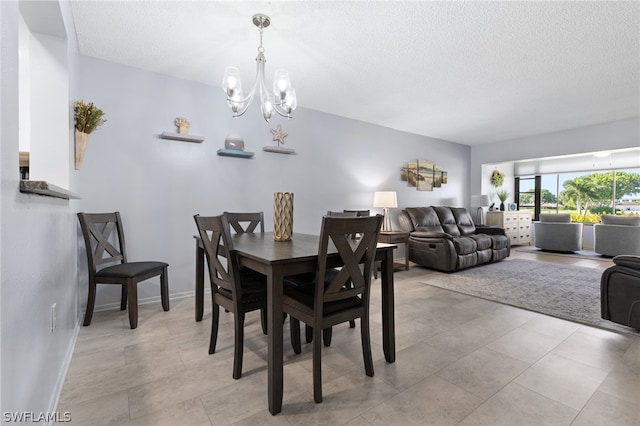 dining area featuring a textured ceiling and a chandelier