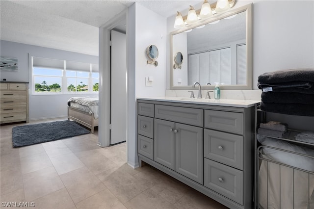 bathroom featuring vanity, tile patterned flooring, and a textured ceiling