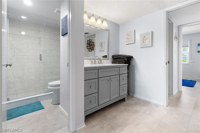 bathroom featuring vanity, a shower with door, toilet, and a textured ceiling